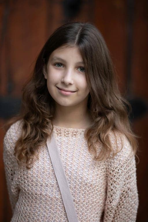 a portrait of a person transformed into a magical girl anime transformation scene, wearing a fitted sailor-style bodice with a bow on the chest, pleated short skirt, long gloves, knee-high boots, glowing ribbons, radiant light effects, dynamic pose, and soft pastel anime lighting