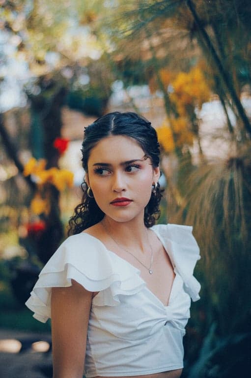 a portrait of a person styled with retro camera visuals, showing yellowed highlights, slightly green or blue color cast, grainy texture, and low dynamic range