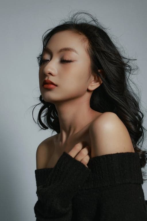 a portrait of a person styled with relaxed 70s-inspired outfit elements, casual flared bottoms, soft knit or cotton tops, understated layering, warm tones, casual stance, and soft lighting