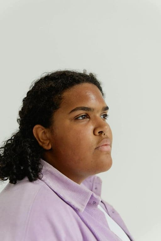 a portrait of a person edited to reshape the lower face by narrowing the jaw and reshaping the chin into a sharper and more pointed form, reducing jaw width substantially, creating a clear V-line face shape without changing eyes nose or mouth