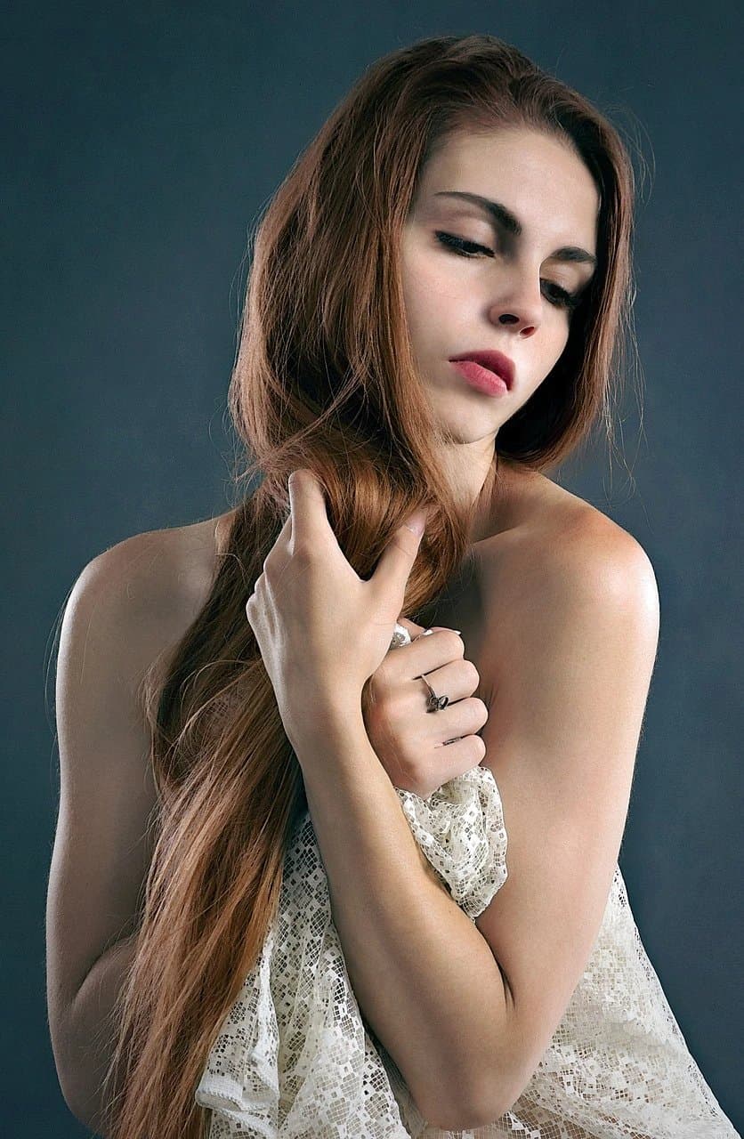 A close-up portrait of a girl with her hands visible but empty.