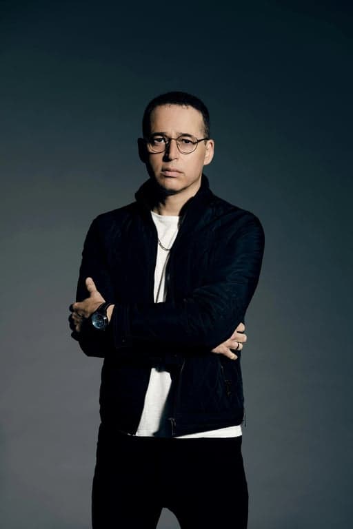 a portrait of a man edited in a Korean perm hairstyle style, so that the top hair has small even waves forming soft curls as seen in Korean men perm cuts, while the sides and back are cut short and remain straight, with curl texture limited only to the top area, and unchanged face and original lighting