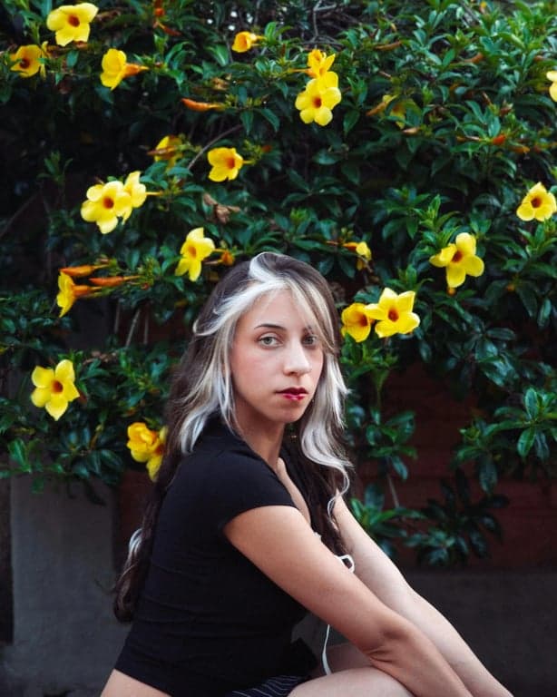 edit the image to create a dating app–ready profile photo by setting an eye-level perspective, correcting posture to look upright and relaxed, improving facial lighting to be soft and evenly distributed, removing harsh shadows under eyes and along the jaw, increasing facial clarity, subtly refining jawline definition without changing identity, simplifying the background, and ensuring the output is clearly more presentable than the original