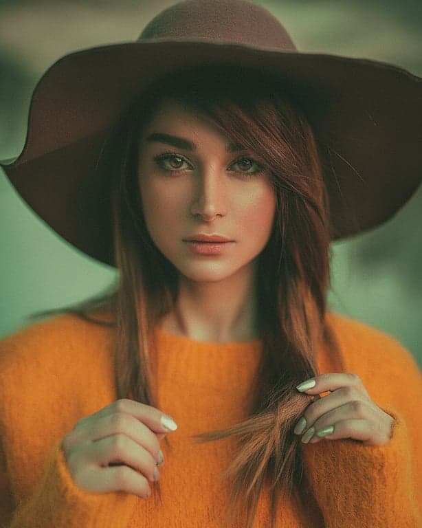 a portrait of a person edited with a cross-processed film look, featuring unnatural color casts (green shadows, magenta highlights) and high contrast