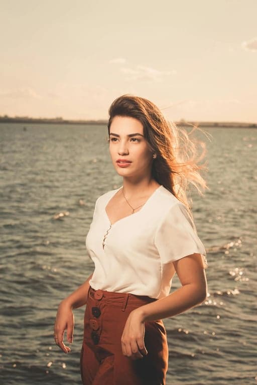 a portrait of a person edited to dramatically reduce waist width by aggressively pulling the waist inward on both sides, while keeping hip width unchanged or visually wider, creating a very high waist-to-hip ratio and an unmistakable hourglass silhouette with an obvious before-and-after difference