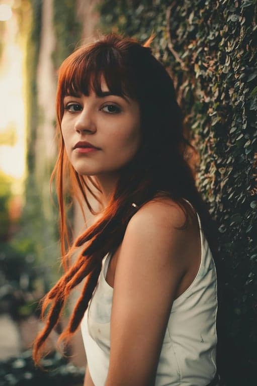 a portrait of a person with aggressive yet realistic double-chin correction: remove under-chin fullness, tighten the neckline silhouette, and create a firm jaw break without altering facial identity; preserve pores, texture, and natural shading; avoid distortion; keep background unchanged; final image should clearly show a slimmer chin and cleaner lower-face structure