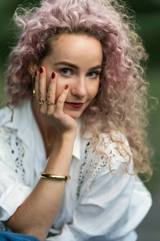 a portrait of a person recolored with pastel pink hair, preserving hair flow, strand separation, and natural shadow depth