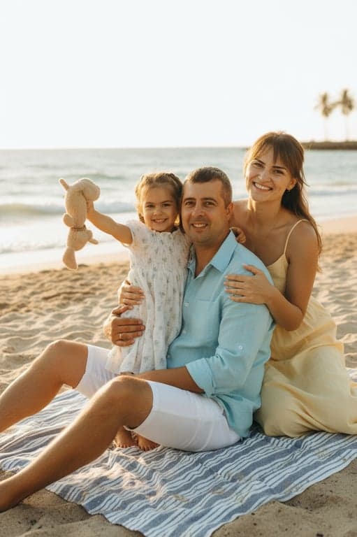 a portrait of a family transformed into a summer-themed family portrait, all members wearing light casual summer clothing such as linen shirts and dresses in soft bright colors, placed in a sunny outdoor environment like a park or beach, using relaxed seated or walking poses, natural smiles, and a fresh joyful atmosphere