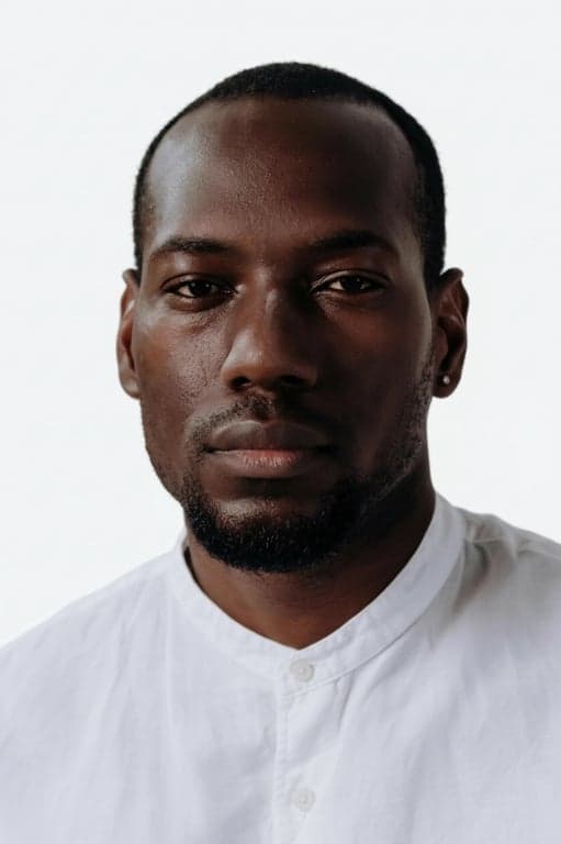 a portrait of a man, official passport photo, plain white background, neutral expression, full face view, even frontal lighting.