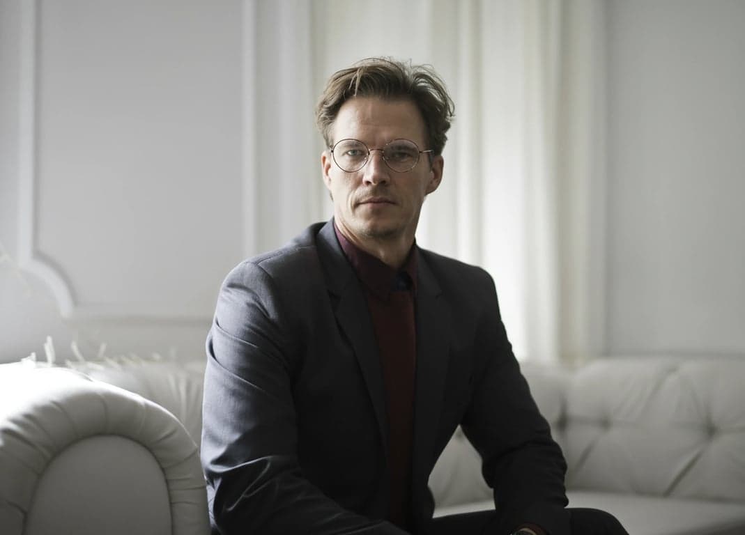 a portrait of a person edited to clean up heavy cast shadows caused by harsh sunlight or indoor lighting, revealing clear facial details without flattening depth