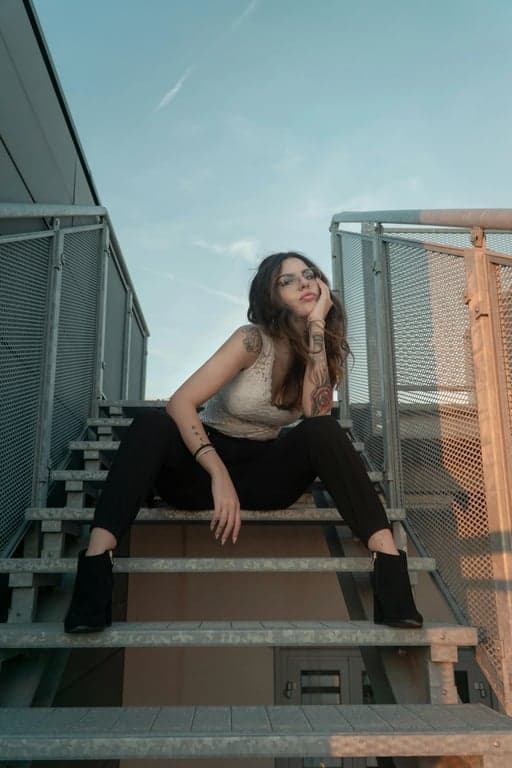 a GTA-style character illustration that keeps the original subject’s identity and posture, simplifies textures into painted surfaces, enhances facial angles and shadows, uses bold outlines and cinematic lighting, and places the character against a minimal GTA poster-style background