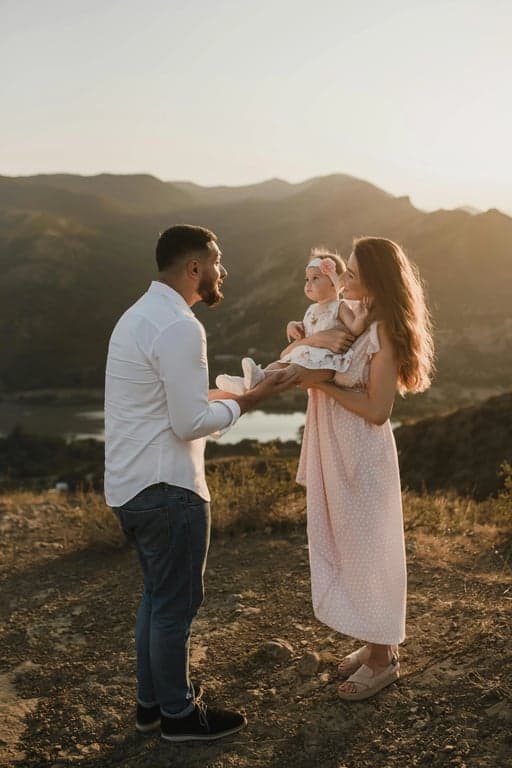 Generate a crest symbolizing adventure and shared stories, inspired by the adventurous spirit and natural, rugged colors (khaki, stone grey) of the family hiking photo. Incorporate mountain peaks and a winding path motif.