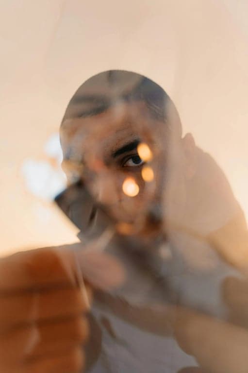 a portrait of a person edited to preserve soft, even face lighting, while removing irregular lens flare, harsh light streaks, and distracting shadow artifacts that interfere with facial readability