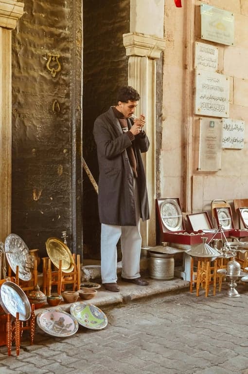 a portrait of a man edited with a cool-toned film grain effect, featuring blueish shadows, fine grain, and a nostalgic fade