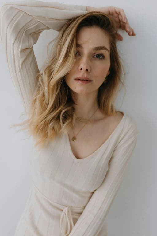 a portrait of a person enhanced with subtle fashion styling, neutral palette, balanced contrast, natural expression, and simple modern backdrop