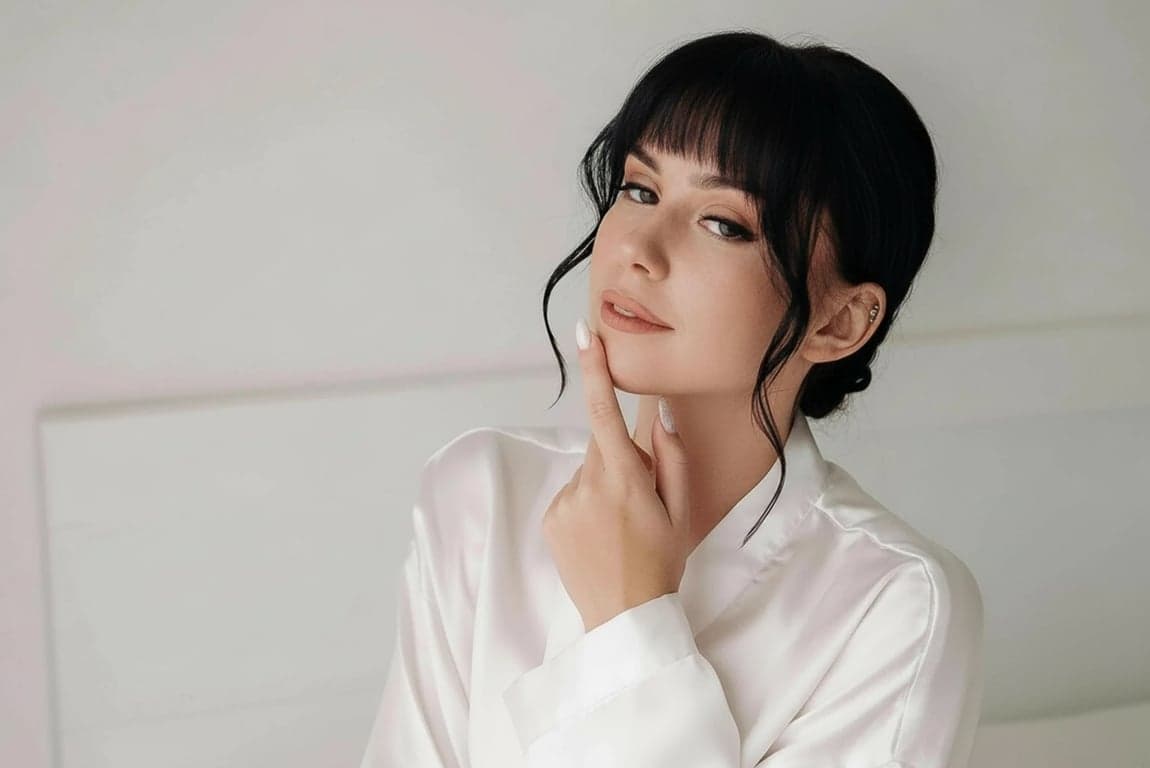 a portrait of a person edited to move the hairline forward in a clear and aggressive way, filling sparse frontal areas so the hair starts lower on the forehead and creates a thicker, more youthful hair frame