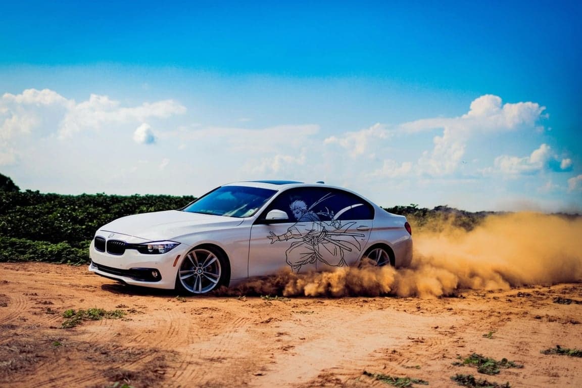 AI anime car sticker after photo - white car in the sand with car sticker