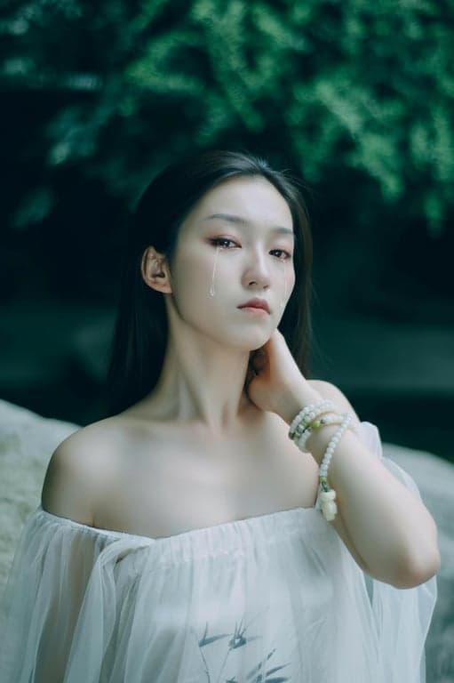 a portrait of a woman, crying filter effect, single realistic tear rolling down cheek, reddened eyes, pouting expression, soft lighting.