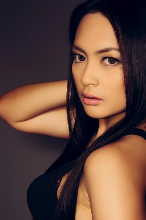 a portrait of a woman with the background changed to a solid light gray studio backdrop, creating a professional and minimalist aesthetic