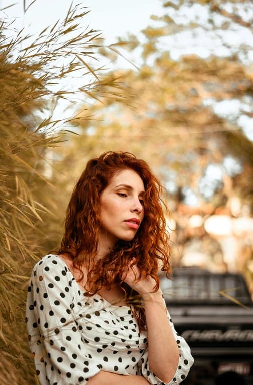 a portrait of a person transformed into a seated posture with legs crossed at the knee in a relaxed manner, torso upright, shoulders open, spine long; posture should convey ease and confidence rather than tension; maintain realistic joint angles; do not modify background