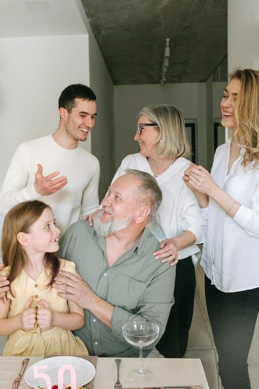 Design a crest that evokes growth and nurturing, using the lush green and rich brown earth tones from the garden photo. Feature a stylized tree whose roots and branches form a continuous circle of protection.