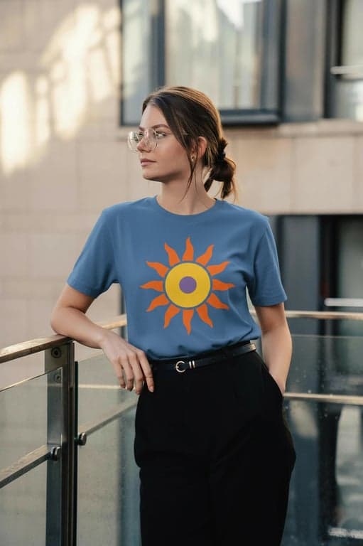 a portrait of a person edited to wear a colorful T-shirt design featuring a flat illustrated object such as a fruit, sun, or abstract symbol, using three to four solid colors only, no gradients, no noise patterns, centered chest placement, preserving natural fabric folds and realistic lighting