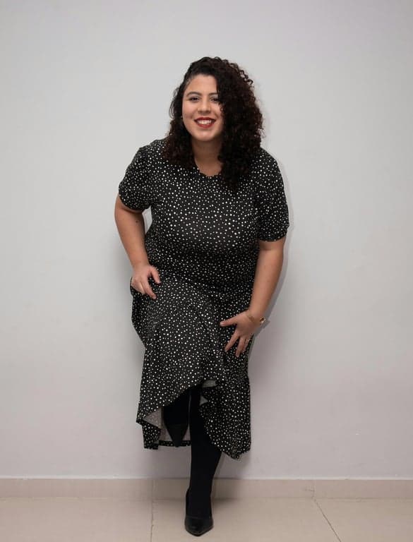 add suit to photo online free – before pic: woman with curly hair in black dress against plain wall