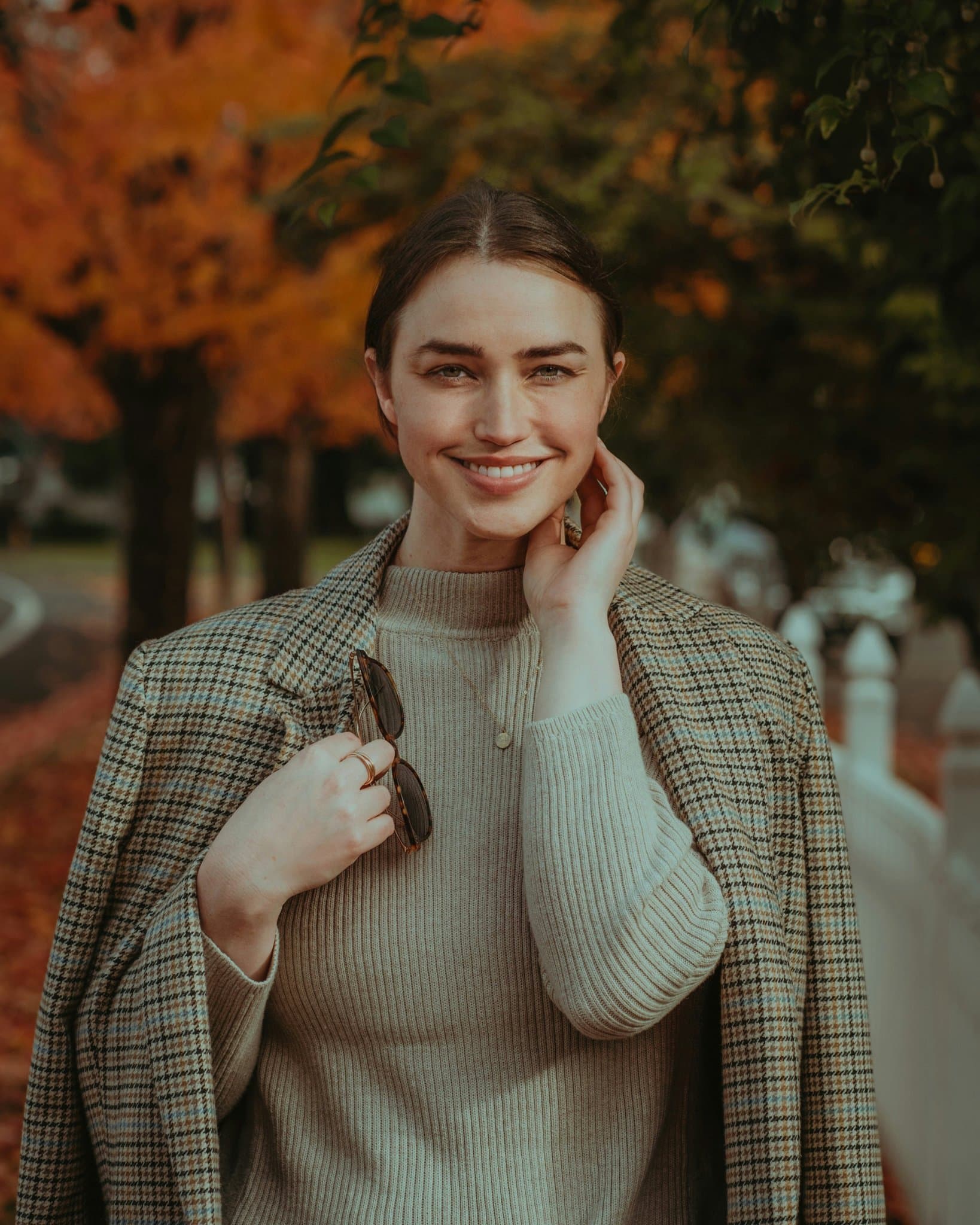 A casual autumn street portrait with warm tones and layered fall fashion.