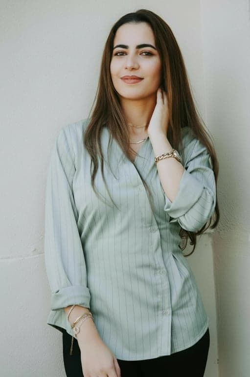 a portrait of a person edited to aggressively reshape the torso by sharply narrowing the waist and preserving full hip volume, producing a bold waist-to-hip contrast and a clearly exaggerated hourglass body shape