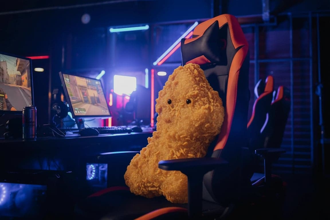 a hyper-realistic chicken nugget sitting in a gamer chair, staring at a computer screen, neon lighting, detailed but absurd scene.