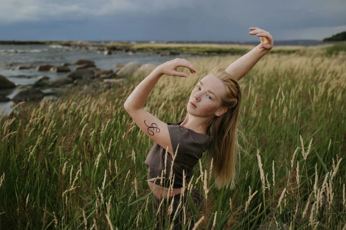 ai tattoo generator after pic - woman dancing in the field with letter tattoo