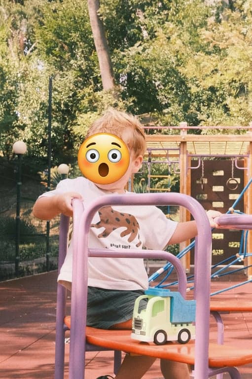 A close-up of a child looking surprised, with a giant 😲 emoji covering their actual mouth and eyes, creating a humorous and seamless replacement effect.