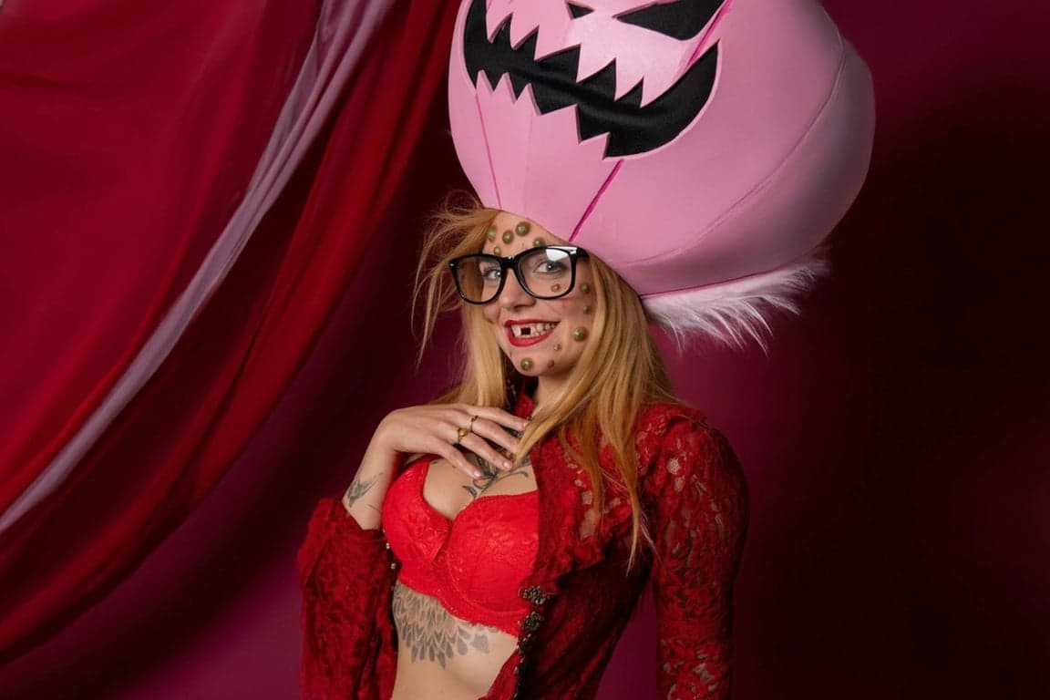 distorted funny girl on stage under pink pumpkin