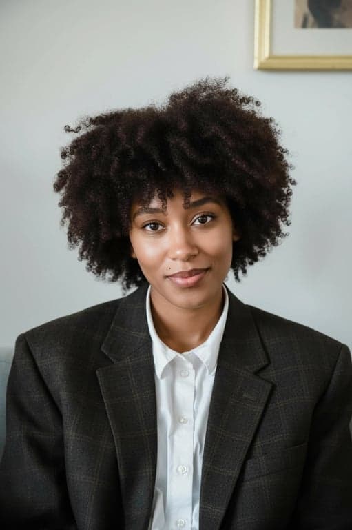 A modern and approachable AI LinkedIn portrait of a woman, slight head tilt, soft retouching, bright catchlights in eyes, cohesive professional aesthetic, ready for profile upload.