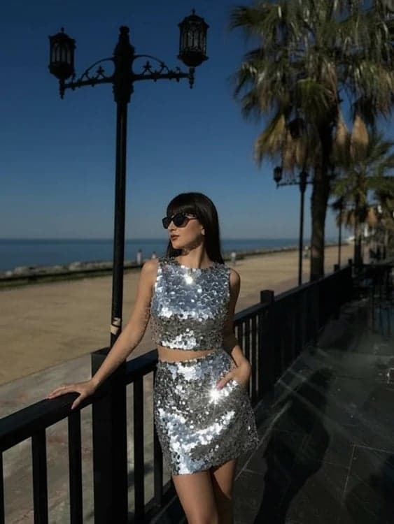 Holiday party outfit after image - person wearing a metallic skirt duo with festive lighting