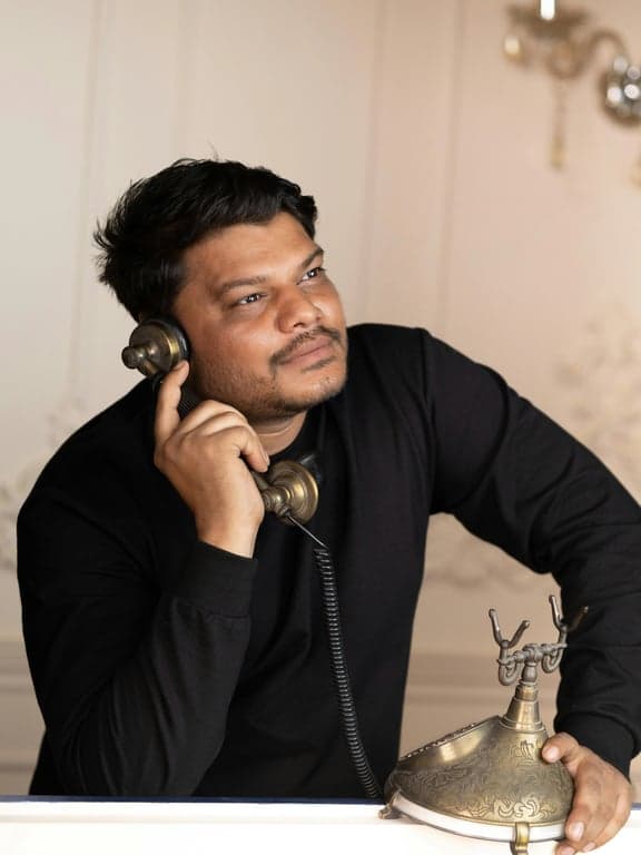 a professional portrait of a man in a suit and tie, sitting in a modern office, confident smile, natural window light, clean and trustworthy appearance.