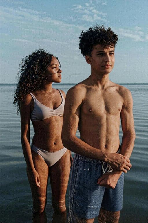 a portrait of a couple transformed to wear different bathing suits than the original, visibly altering swimsuit coverage, neckline depth, side exposure, and bottom shape for each person, while maintaining realistic fabric behavior, smooth seams, correct anatomy, natural pose, and clean lighting