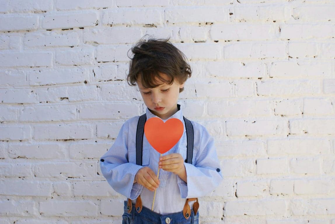 AI baby Christmas photo before photo - boy looking at heart stick
